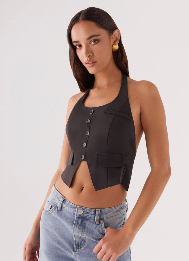 Womens Kendra Backless Vest in the colour Black in front of a light grey background